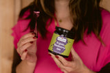 Woman in pink shirt holding Clif Family Organic Blackberry Jam