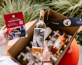 Someone opening a Clif Family The Wine Drop shipment of wine
