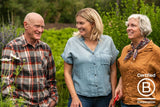 Clif Family's Co-Owner & Co-Founders Gary Erickson and Kit Crawford stand in a lush green field at the Clif Family Farm with President Linzi Gay, celebrating B Corp Month.||||||||||||||||||