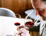 Man comparing two glasses of red wine during a wine tasting