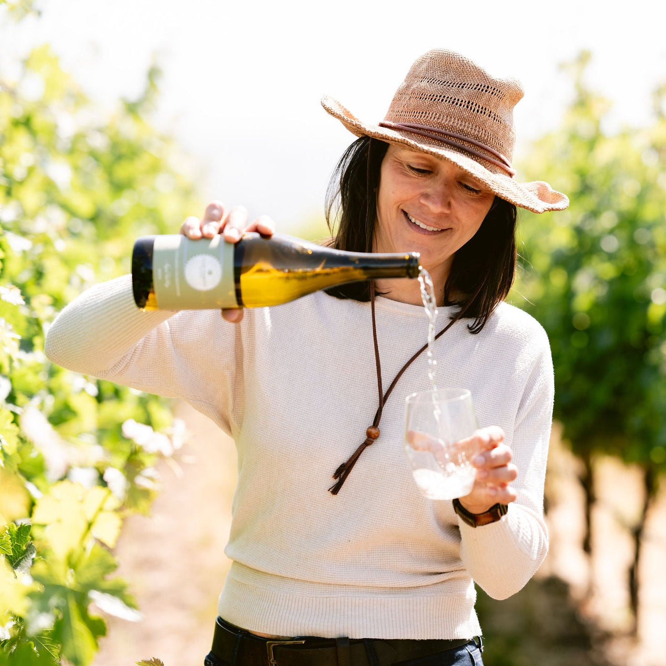 Woman pouring wine in a vineyard