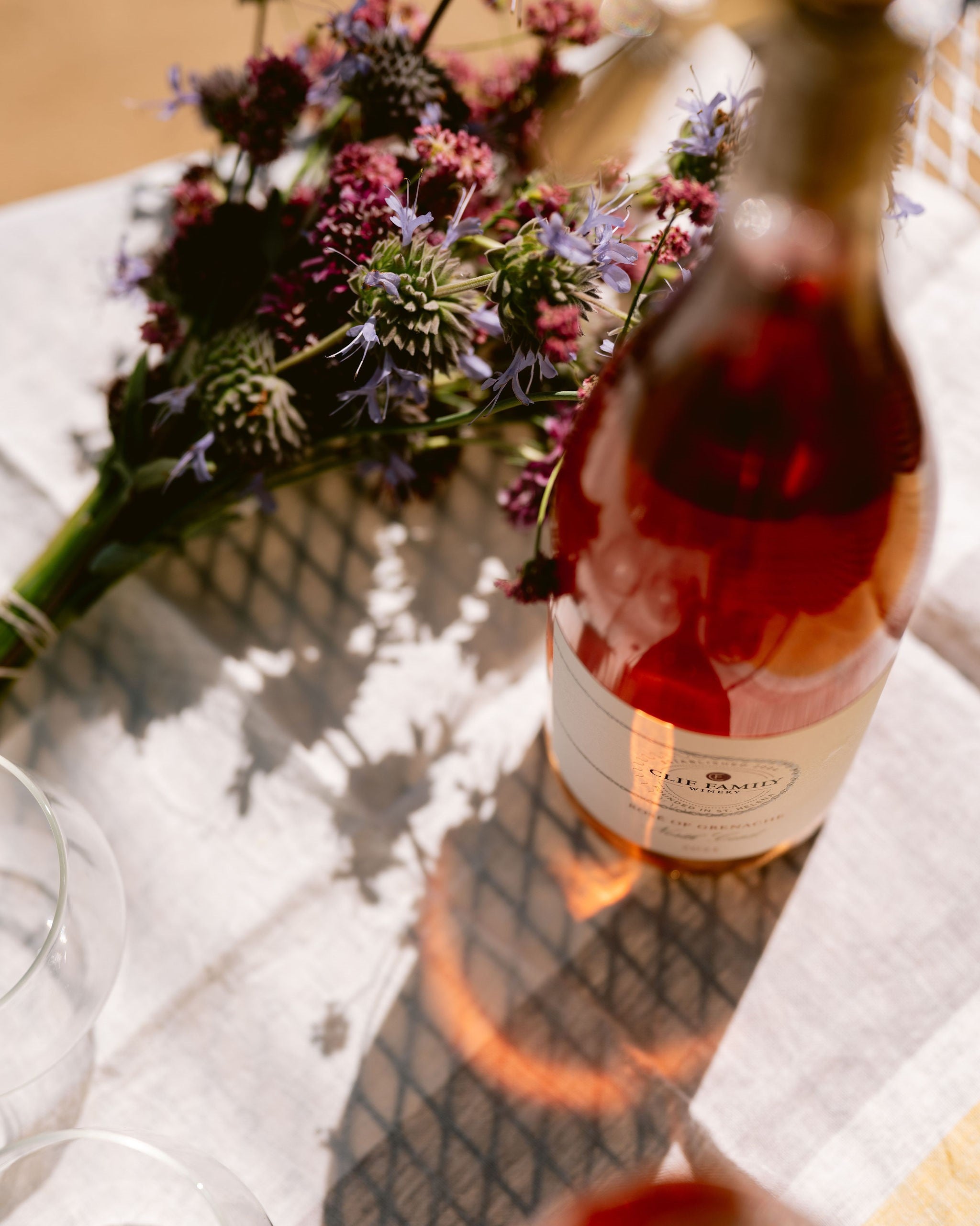 Bottle of rose wine with a bouquet of flowers on a tablecloth