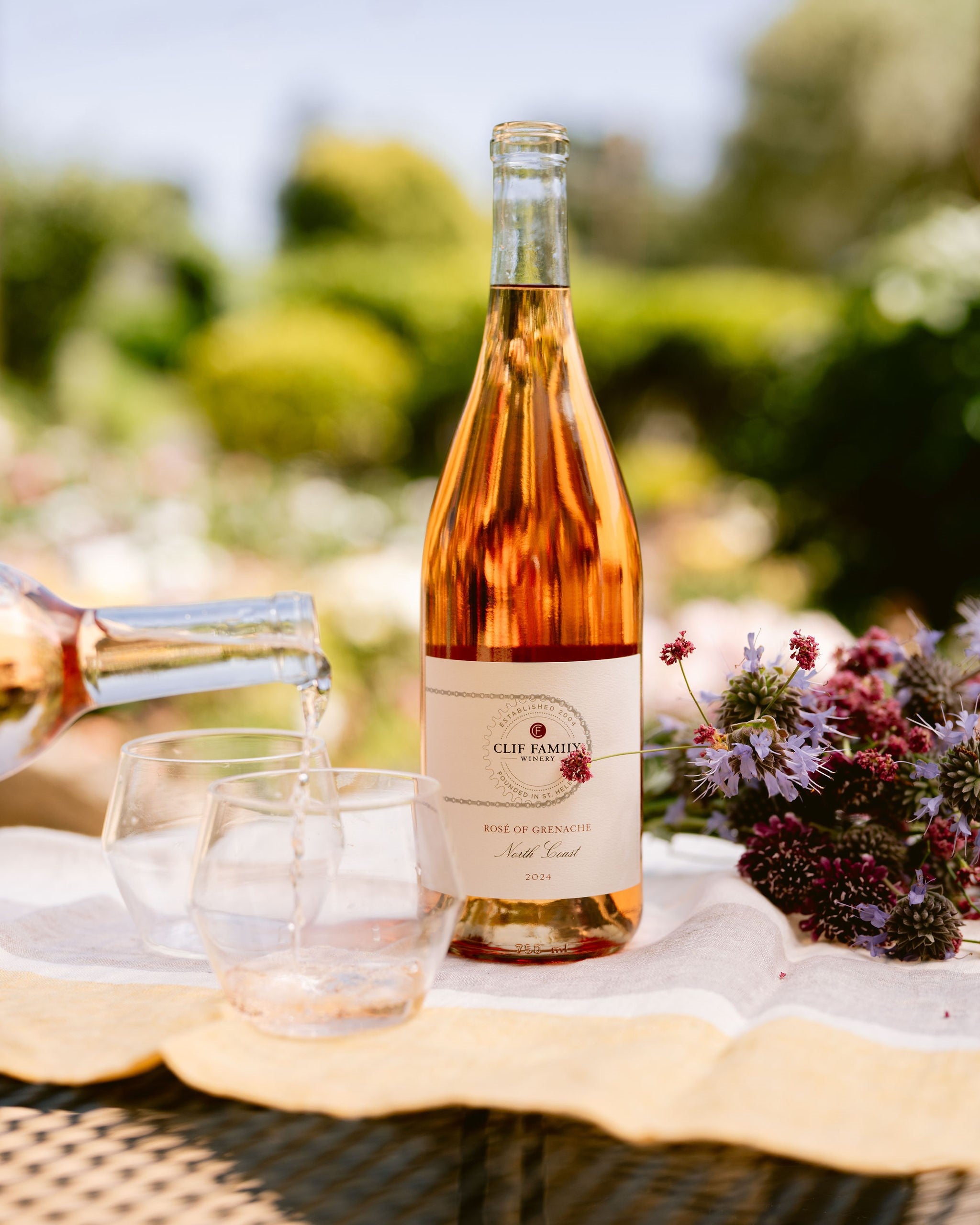 Bottle of rose wine with glasses on a table outdoors