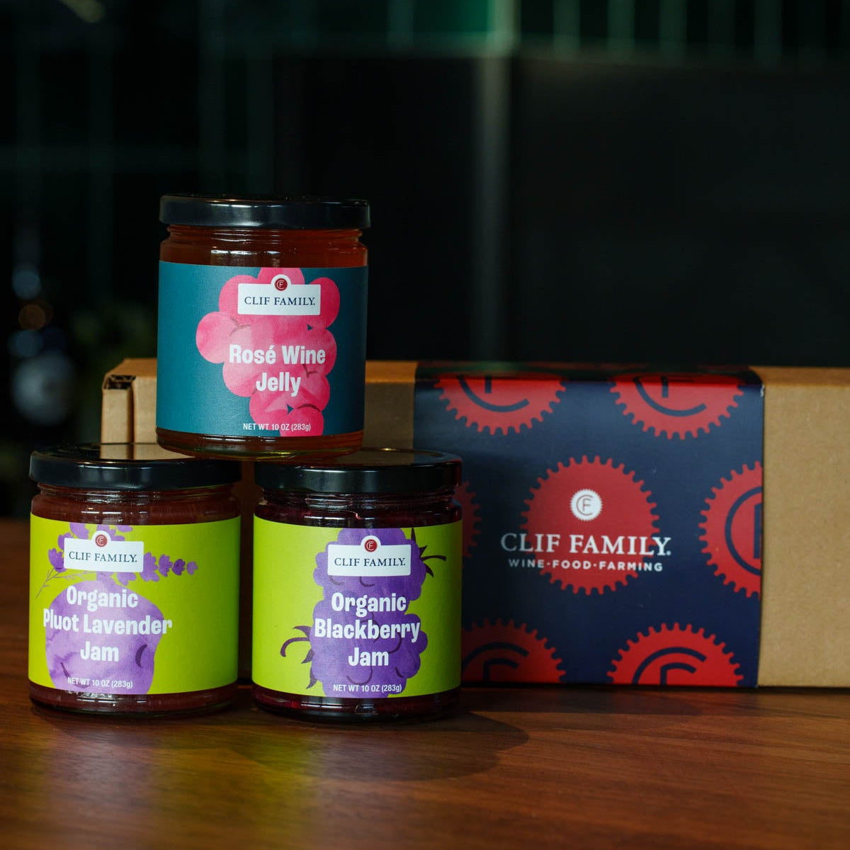 Clif Family organic jam jars on a wooden surface with a box in the background.