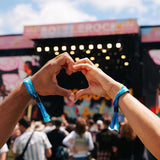 Two hands making a heart shape in front of a music festival stage with 'BottleRock' branding.